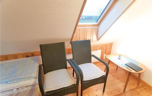 two chairs and a table in a room with a window at Lovely Home In Lärbro in Slite