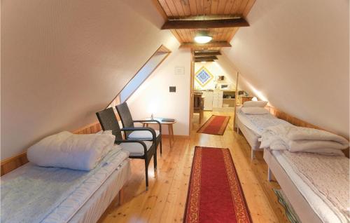 a attic room with three beds and a table at Lovely Home In Lärbro in Slite