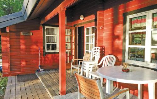 un porche de una casa roja con mesa y sillas en Cozy Home In Lilla Edet With Kitchen, en Lilla Edet