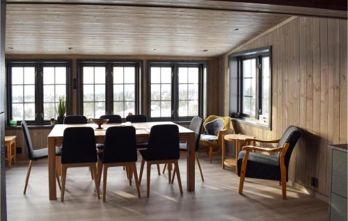 jadalnia ze stołem, krzesłami i oknami w obiekcie 3 Bedroom Lovely Home In Sjusjøen w mieście Sjusjøen