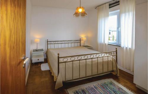 a bedroom with a large bed and a window at Amazing Home In Bunkeflostrand With 3 Bedrooms in Bunkeflostrand
