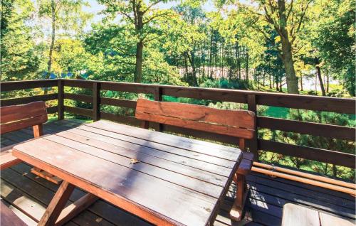 un banc en bois posé sur une clôture en bois dans l'établissement Lovely Home In Swietajno With Kitchen, à Świętajno