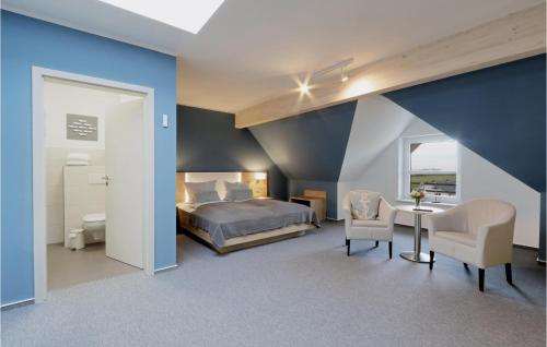 ダゲビュルにあるAmazing Apartment In Dagebll With Wifiのベッドルーム1室(ベッド1台、テーブル、椅子付)
