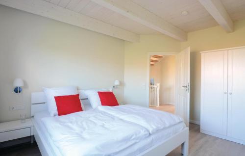 um quarto com uma grande cama branca com almofadas vermelhas em Gorgeous Home In Dagebll With Wifi em Dagebüll