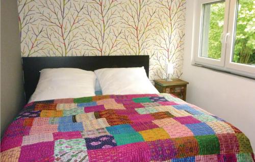 ein Schlafzimmer mit einem Bett mit einer bunten Decke in der Unterkunft Stunning Home In Klein Nemerow With 1 Bedrooms in Klein Nemerow