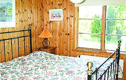 a bedroom with a bed and a lamp and a window at Lovely Home In Ljungsarp With Sauna in Ljungsarp