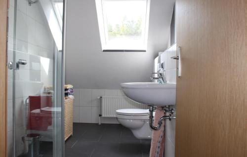 een badkamer met een toilet, een wastafel en een raam bij 2 Bedroom Nice Apartment In Wesertal-gieselwerder in Gewissenruh