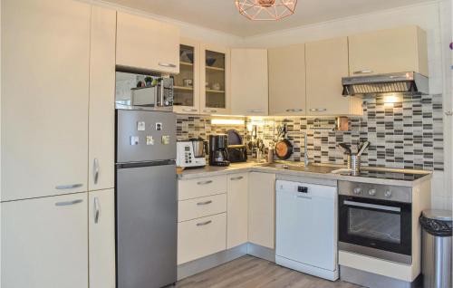 Il comprend une cuisine équipée d'un réfrigérateur et d'une cuisinière. four supérieur dans l'établissement Amazing Home In Hermanville-Sur-Mer, à Hermanville-sur-Mer