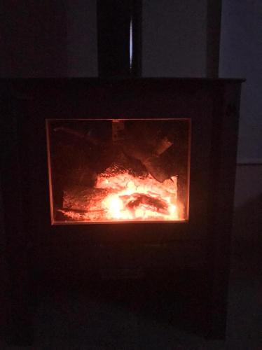 um fogão com fogo no escuro em AYRES DE BRANDSEN em Brandsen