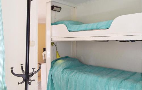 2 Etagenbetten in einem Zimmer mit blauer Bettwäsche in der Unterkunft 2 Bedroom Stunning Home In Lderup in Löderup