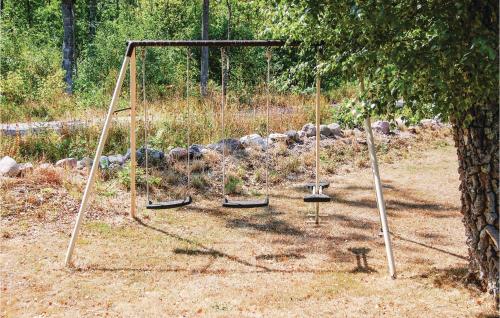 an empty swing set next to a tree at Äspelund in Boda