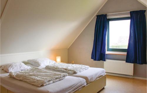 1 dormitorio con 2 camas, cortinas azules y ventana en Waterjuffer, en Tzummarum