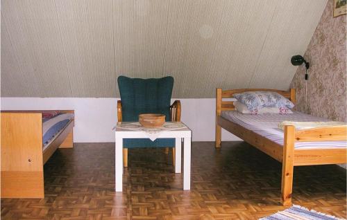 ビンメルビューにあるNice Home In Vimmerby With Kitchenのベッド、テーブル、椅子が備わる客室です。