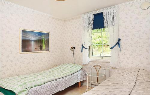 a bedroom with two beds and a window at Lovely Home In Fjrs With House Sea View in Vågerse