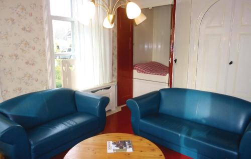 a living room with two blue chairs and a table at 3 Bedroom Cozy Apartment In Paesens in Paesens
