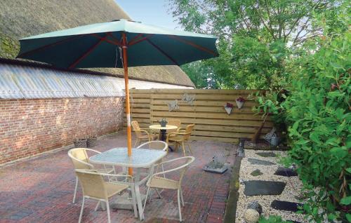 a table and chairs with an umbrella on a patio at 3 Bedroom Cozy Apartment In Paesens in Paesens