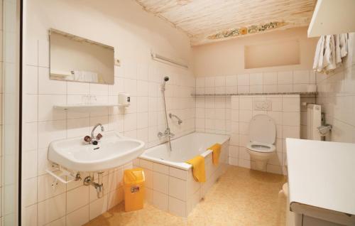 a bathroom with a sink and a tub and a toilet at Amazing Apartment In Wagrain With 1 Bedrooms, Wifi And Outdoor Swimming Pool in Wagrain