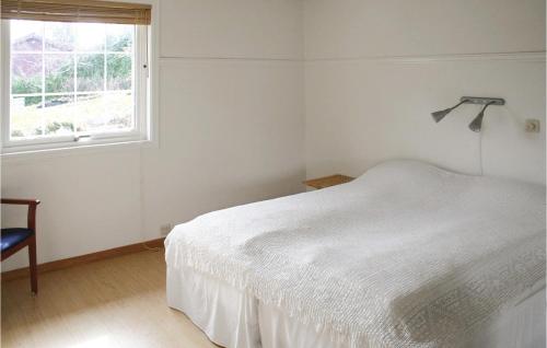 a bedroom with a white bed and a window at Awesome Home In Sandnes With 5 Bedrooms, Sauna And Wifi in Idse