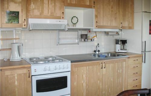 Il comprend une cuisine équipée d'une cuisinière blanche et d'un évier. dans l'établissement Gorgeous Home In Silverdalen With Kitchen, à Silverdalen