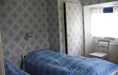 - une chambre avec un lit bleu et un miroir dans l'établissement 2 Bedroom Lovely Home In Frsund, à Fårösund