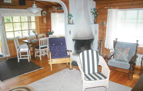 a living room with two chairs and a fireplace at Cozy Home In Hammar With Sauna in Hammarö
