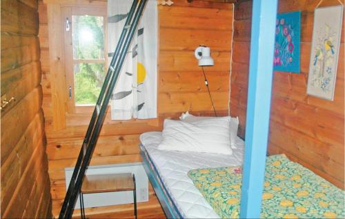 een kamer met een bed in een houten hut bij Cozy Home In Hammar With Sauna in Hammarö