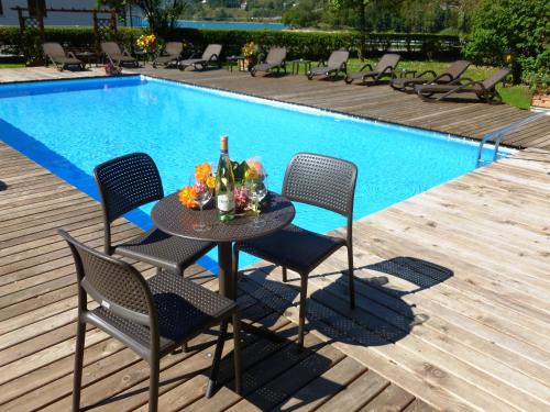 un tavolo con sedie accanto alla piscina di Hotel Cima d'Oro a Ledro