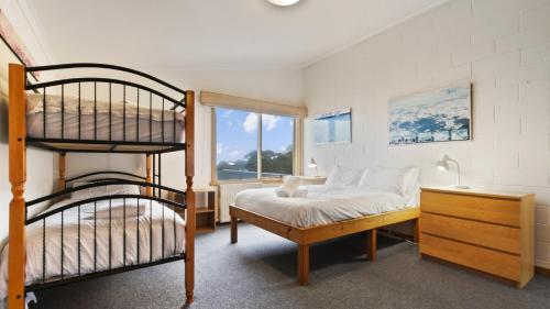 ein Schlafzimmer mit einem Etagenbett neben einem Fenster in der Unterkunft Alpine Haven 3 in Mount Hotham