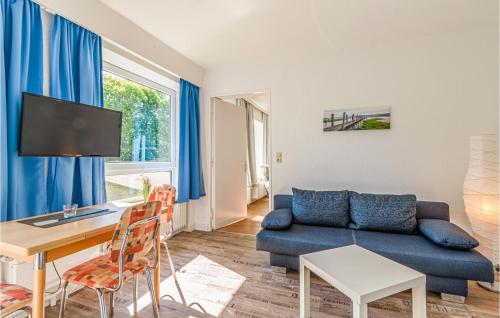 a living room with a blue couch and a table at Stunning Apartment In St Annen in Sankt Annen