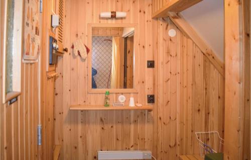 a bathroom with wooden walls and a mirror and a sink at Amazing Home In Gemla With Kitchen in Gemla