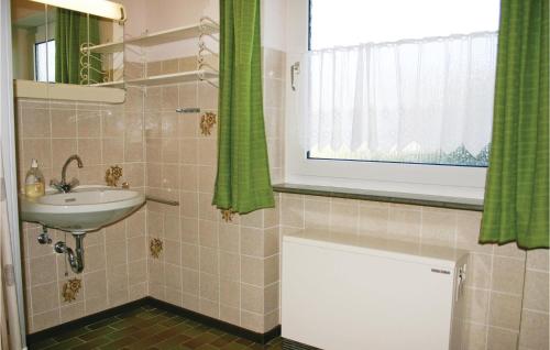 a bathroom with a sink and a green curtain at Stunning Home In Oberaula Ot Hausen in Hausen