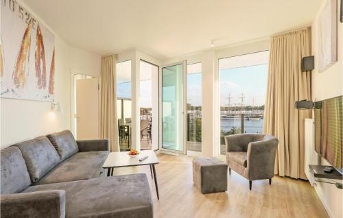 a living room with a couch and chairs and windows at Highend Travemünde - Whg 408 in Travemünde