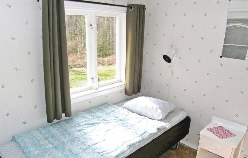 a small bedroom with a bed and a window at Nice Home In Hjltevad With 1 Bedrooms in Hjältevad