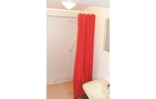 a bathroom with a red shower curtain and a sink at Nice Home In Hjltevad With 1 Bedrooms in Hjältevad