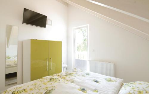 ein Schlafzimmer mit einem Bett und einem gelben Schrank in der Unterkunft Seerose 8 in Süssau