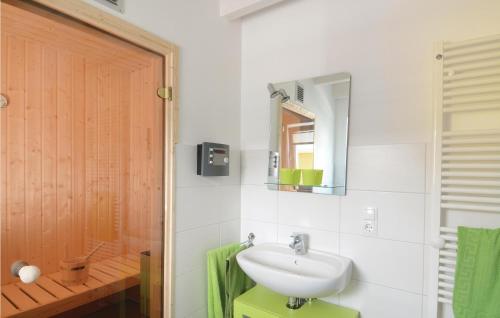 ein Bad mit einem Waschbecken und einem Spiegel in der Unterkunft Seerose 8 in Süssau