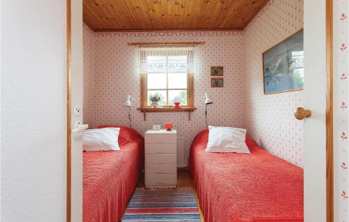 two beds in a small room with a window at Nice Home In Kpingsvik With Kitchen in Kårehamn