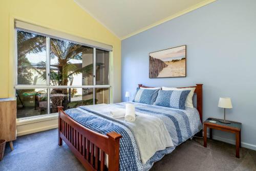 a bedroom with a bed and a large window at Beachy Haven at Sails close to the Beach in Inverloch