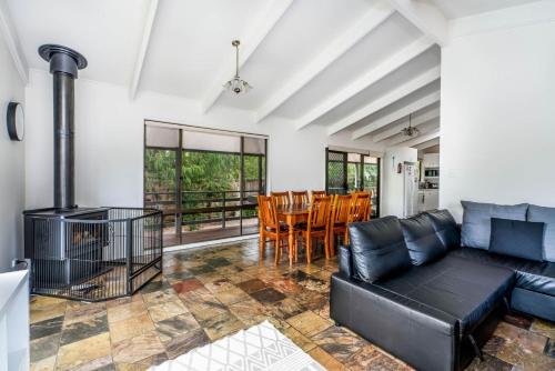 a living room with a couch and a table and chairs at Wavelength Free Wifi and Pet Friendly outside only in Inverloch