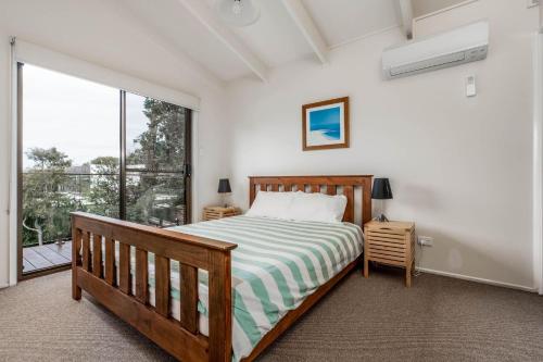 - une chambre avec un lit et une grande fenêtre dans l'établissement Wavelength Free Wifi and Pet Friendly outside only, à Inverloch