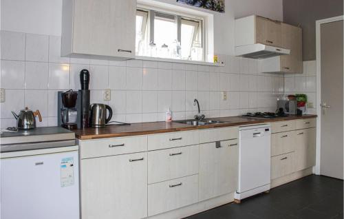 a kitchen with white cabinets and a sink and a window at Awesome Home In Acquoy With Wifi in Acquoy