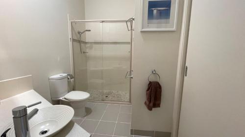 a bathroom with a shower and a toilet and a sink at Romantic Retreat Inverloch in Inverloch
