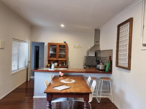 a kitchen with a wooden table and chairs in a room at Sunset Beach Shack on Surf in Inverloch