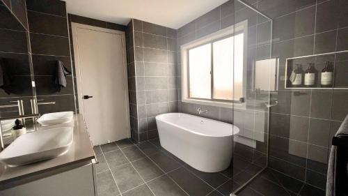 a bathroom with a white tub and a sink at Somerset on Murray in Inverloch