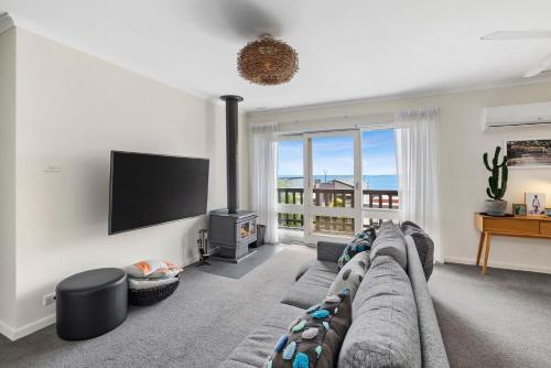 a living room with a couch and a flat screen tv at 1 Luana in Lorne