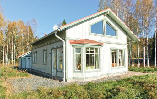 a small white and green house in the woods at Holiday Home Östra Berga Lysvik in Lysvik