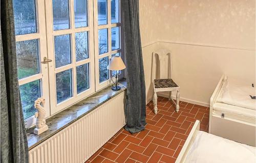 um quarto com uma janela com um candeeiro e uma cadeira em Beautiful Home In Norddeich With Kitchen em Norddeich
