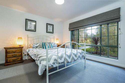a bedroom with a bed and a large window at Ripple Dream Inverloch in Inverloch