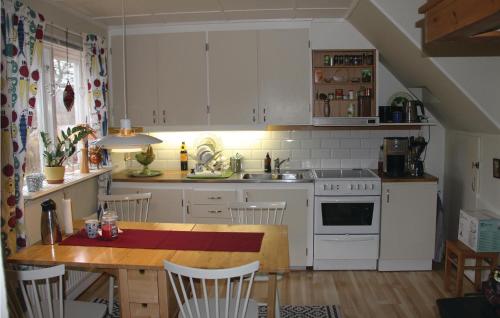 eine Küche mit weißen Schränken und einem Holztisch in der Unterkunft Holiday Home Sölvesborg With Fireplace Iii in Sölvesborg