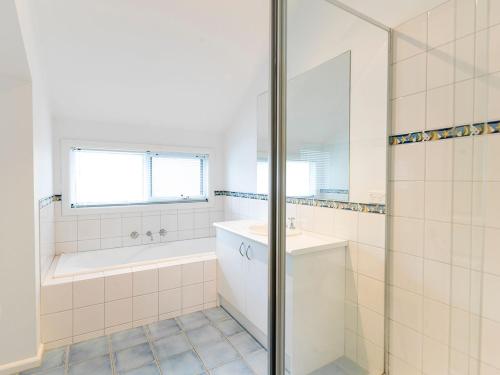 a bathroom with a tub and a sink and a shower at Evergreen Beach House in Inverloch